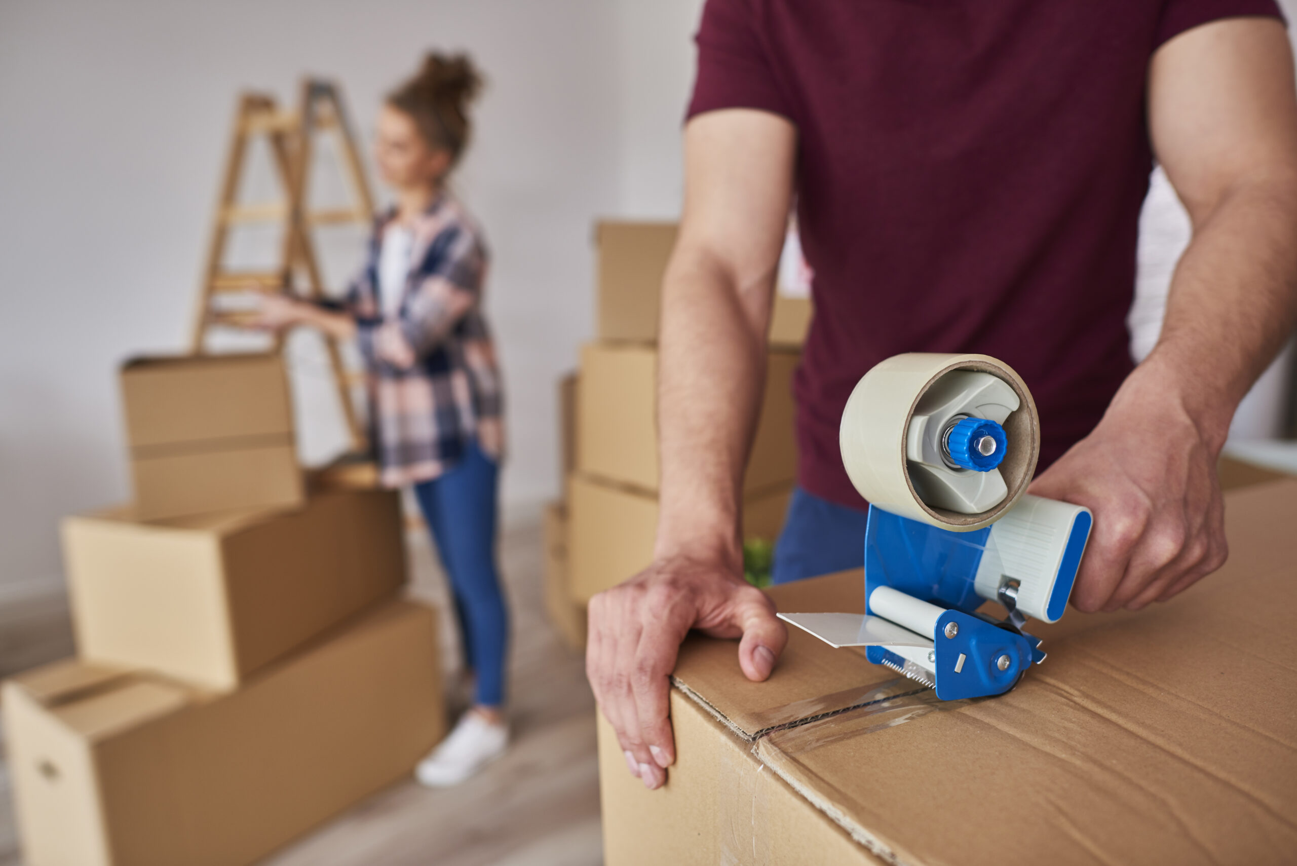 Man with adhesive tape packing boxes